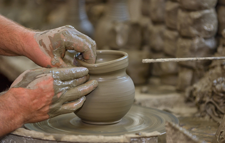 Hands working on pottery wheel in workshopの写真素材