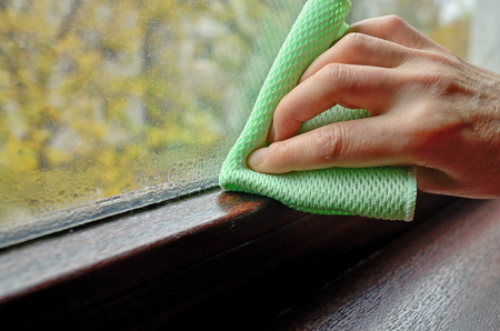 Woman cleaning water  condensation on windowの写真素材