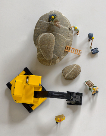 Pebbles stack and figurines of construction workersの写真素材