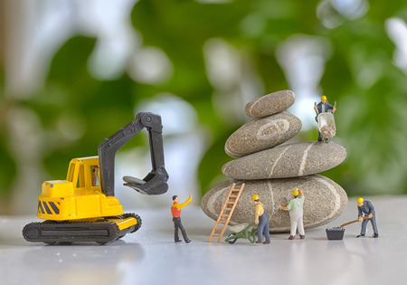 Pebbles stack and figurines of construction workersの写真素材