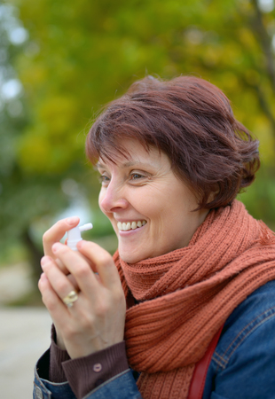 Woman using throat spray in cold seasonの写真素材