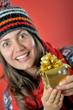 Surprised young woman with Christmas present boxの写真素材