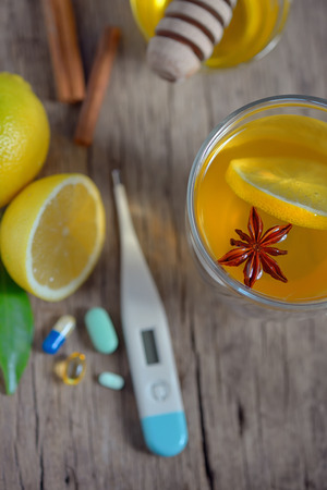 Hot lemon tea and pills on wooden tableの写真素材