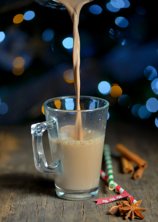 Cup of hot a beverage and Christmas tree lightsの写真素材