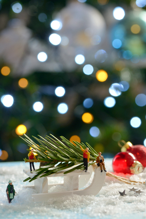 Christmas tree and sleigh decoration with figurines on fake snowの写真素材
