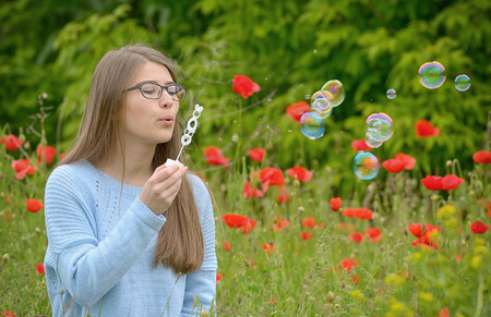 portrait of young girl with soap bubbles in forestの写真素材