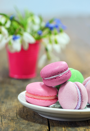 Colorful macaroons and spring flowers on wooden tableの写真素材
