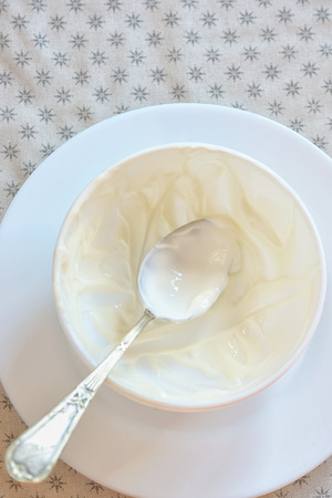 Emty ceramic bowl of white yoghurt and spoonの写真素材