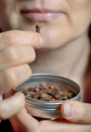 Woman chew dried clove spice for fresh breathの写真素材