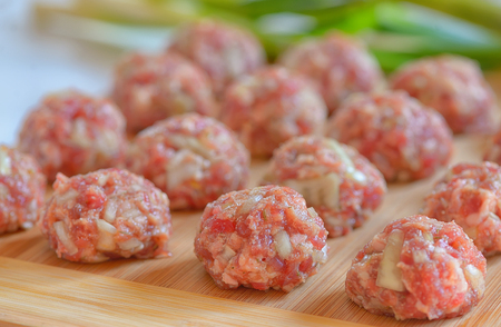 Raw Uncooked Meatballs on wooden plateの写真素材
