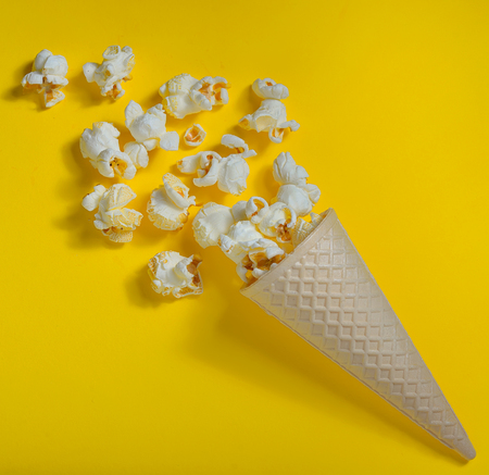 Popcorn in ice cream cones on yellow backgroundの写真素材