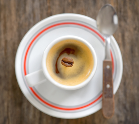 Cup of espresso coffee and one beanの写真素材