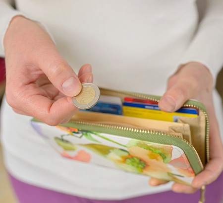 Woman hands counting coins and her walletの写真素材