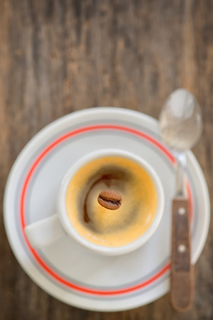 Cup of espresso coffee and one beanの写真素材