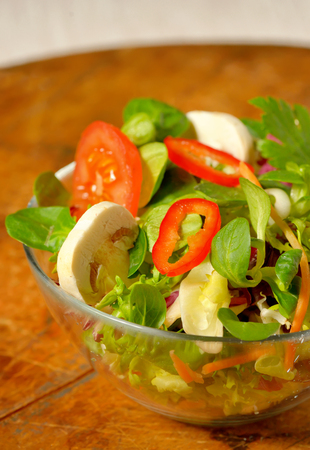 Tasty fresh salad on wooden tableの写真素材