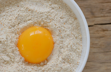 Flour and egg ready for mixing on wooden tableの写真素材