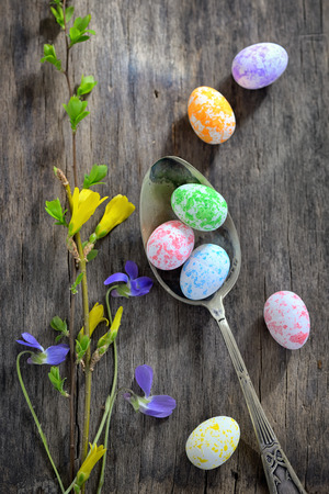 Easter wooden table setting with eggs and flowersの写真素材