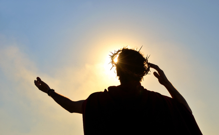 Jesus Christ with crown of thorns against the sunの写真素材