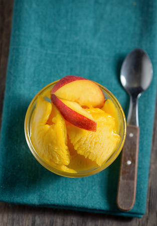 Home made mango ice sorbet with peach slicesの写真素材