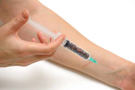 Coffee beans in syringe acting injectionの写真素材