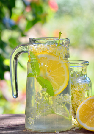 Elder lemonade with lemon on old table woodの写真素材
