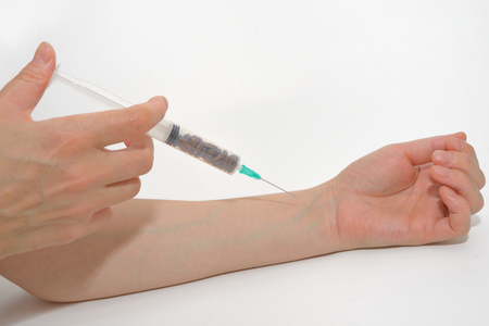 Coffee beans in syringe acting injectionの写真素材