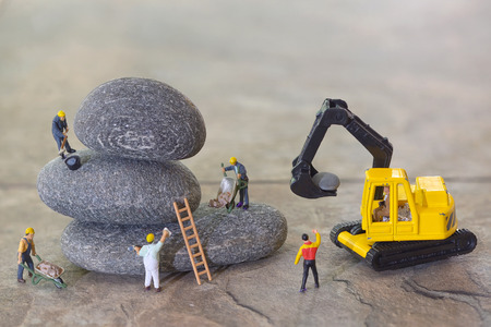 Pebbles stack and workers figurinesの写真素材