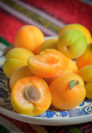 Ripe apricots fruits on rustic plateの写真素材