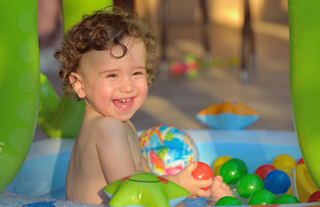 Laughing little girl swimming in the small poolの写真素材