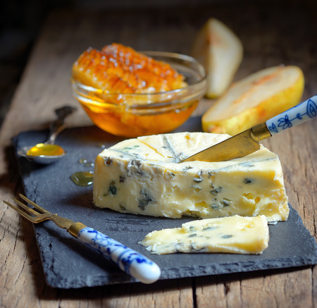 Blue Cheese and honey on ardesia plateの写真素材