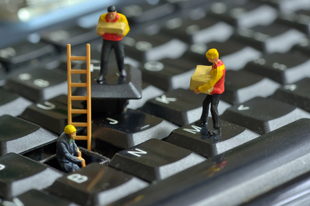Workers figurnes repairing keyboardの写真素材