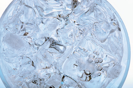Glass with frozen ice cubes isolated on whiteの写真素材
