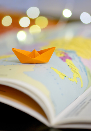 Paper boat on a atlas book map of the worldの写真素材