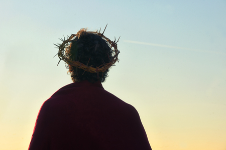 Jesus Christ with crown of thorns against the sunの写真素材