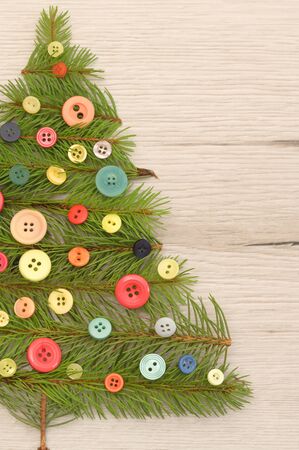 Christmas Tree Made With Pine Branches And Buttons on Wooden Tableの写真素材