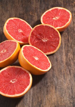 Sliced Red Ripe Grapefruits On Wooden Tableの写真素材
