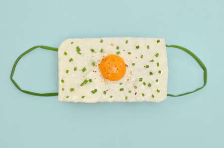 Conceptual Medical Masks. Fried Egg and Green Spring Onions Shallotsの写真素材