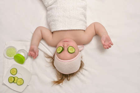 Little Baby Girl Enjoy Spa Applying Cucumber On Faceの写真素材