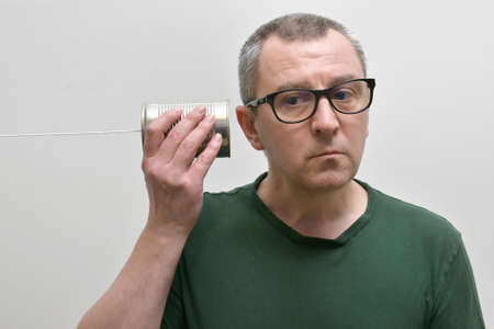 Portrait Of A Man Using and Listening A Tin Can Phoneの写真素材