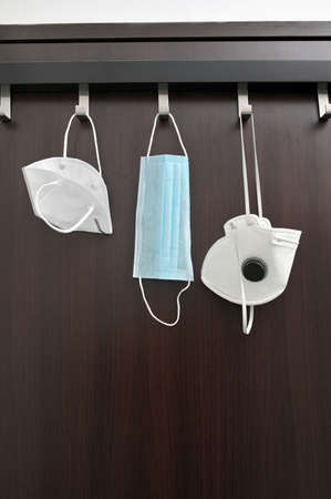 Conceptual Types of Medical Masks Hanging on Hangerの写真素材
