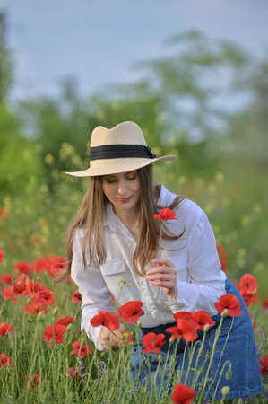 beautiful young girl in the spring poppy fieldの写真素材