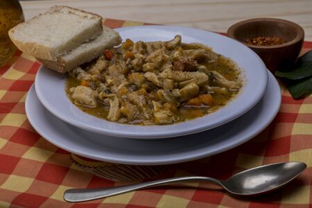 Spanish tripe on wooden table with rustic tablecloth