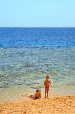 ma and son playing on beach on background blue skyの写真素材