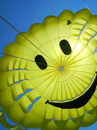 yellow fun parachute with smiling personの写真素材