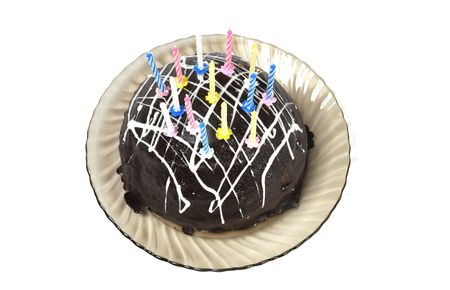 Chocolate cake with candles in plate on a white backgroundの写真素材