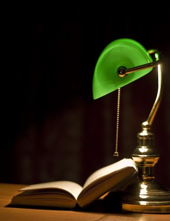 Electric green table lamp and opened bookの写真素材