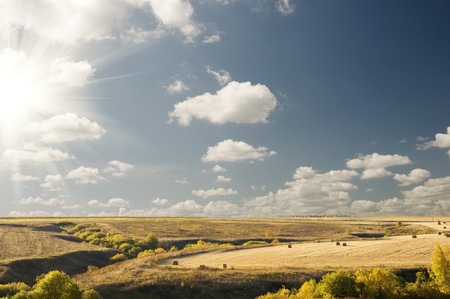 Big cloudy blue sky above an autumn landscape in countryside