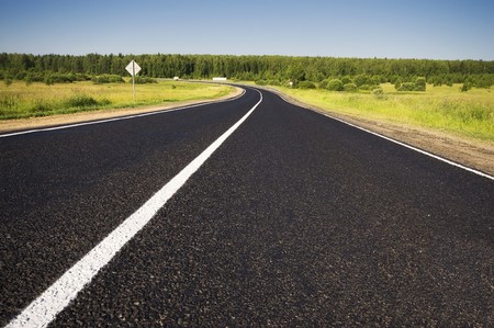 Road in a rural area with trees and blue skyの写真素材