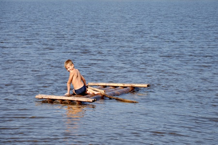 Young boy on raft in the water riverの写真素材