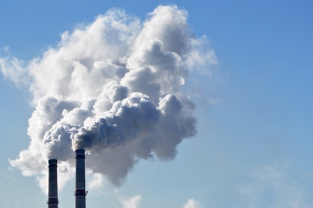 industrial smoke from chimney on blue skyの写真素材